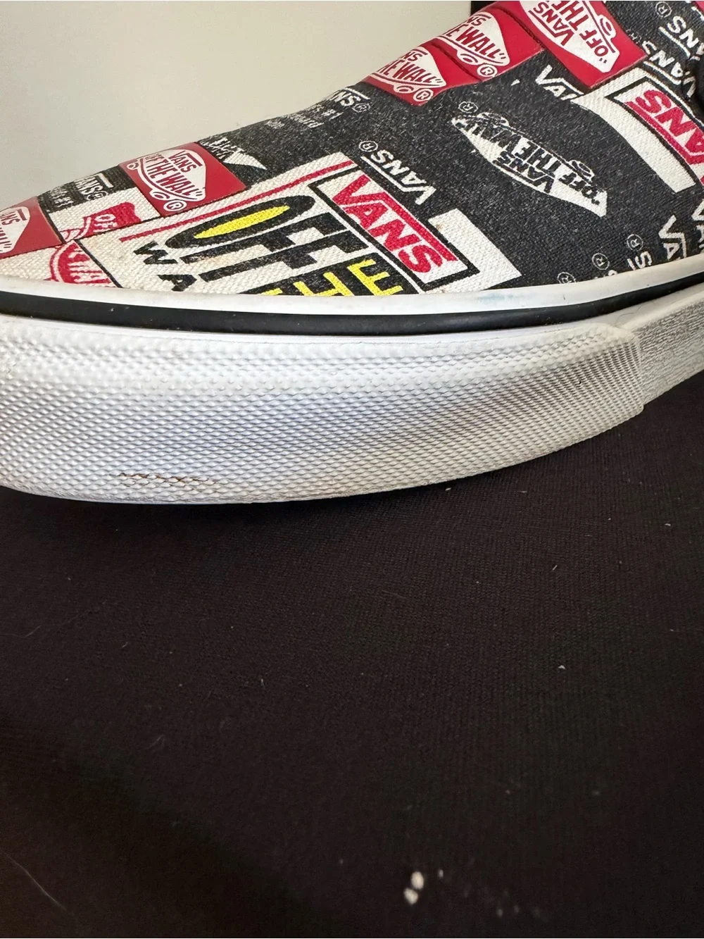 Vans Slip-On Sneakers in Black, White & Red Logo Print